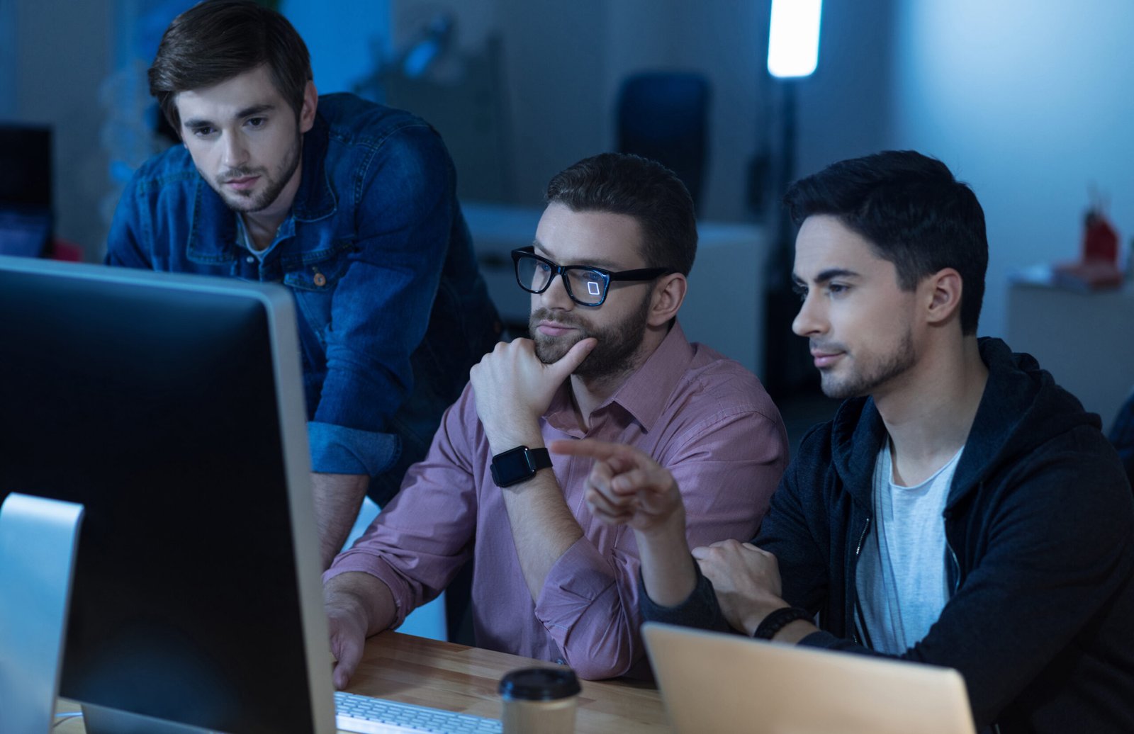 try check this intelligent handsome brunette man sitting with his colleagues front computer pointing it while working together scaled